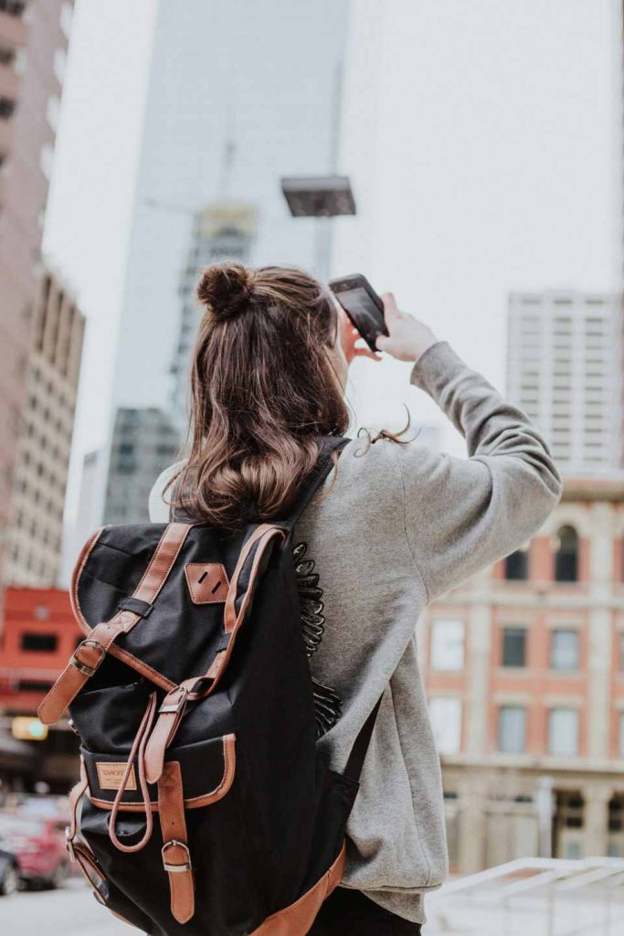 Traveller taking photo in urban city setting.