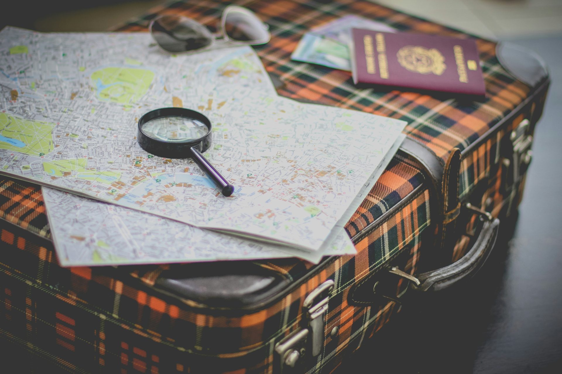 Travel suitcase with maps, passport, and glasses